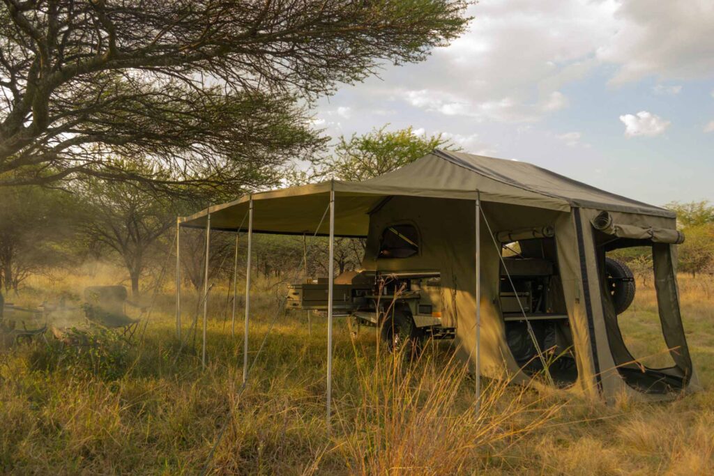 The Summit "Everest" off-road trailer with pitched tent and 180-degree awning at a campsite in the African bush